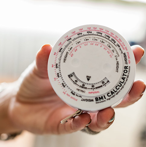 Hand mit einem Body Mass Index Rechner