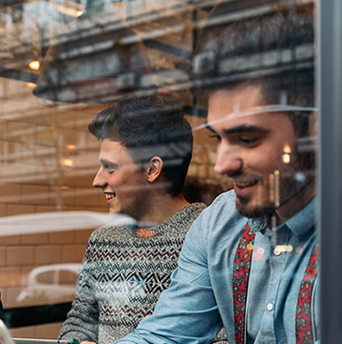 Blick durchs Fenster auf zwei Männer in einem Cafe